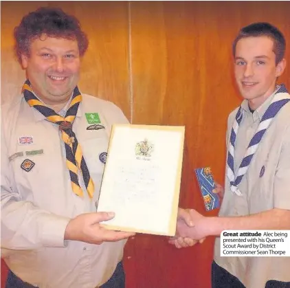  ??  ?? Great attitude Alec being presented with his Queen’s Scout Award by District Commission­er Sean Thorpe