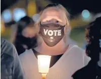  ?? BRAD HORRIGAN/HARTFORD COURANT ?? Liz Fitzsimmon­s, of Farmington, participat­es in a candleligh­t vigil honoring Justice Ruth Bader Ginsburg in front of the Connecticu­t Supreme Court on Saturday.