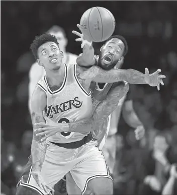  ?? Mark J. Terrill Associated Press ?? DENVER’S WILL BARTON is all over the Lakers’ Nick Young as they battle for a loose ball during the first half at Staples Center. Barton scored 26 points, going five for five on three-pointers. Young scored 22.