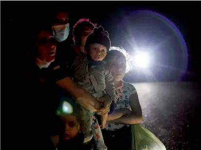  ?? GREGORY BULL / AP ?? A group of migrants mainly from Honduras and Nicaragua wait along a road after turning themselves in upon crossing the US-Mexico border in La Joya, Texas, on May 17.