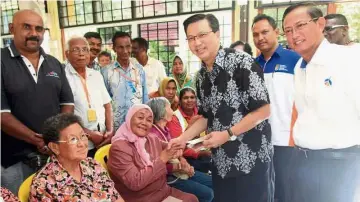  ??  ?? Welcome aid: Liow handing over the monetary assistance to the storm victims at SMJK Khai Mun, in Bentong. With him are Hoh (right) and the Civil Defence Force’s Bentong district officer Mohd Zulkhairi Adek Awang.