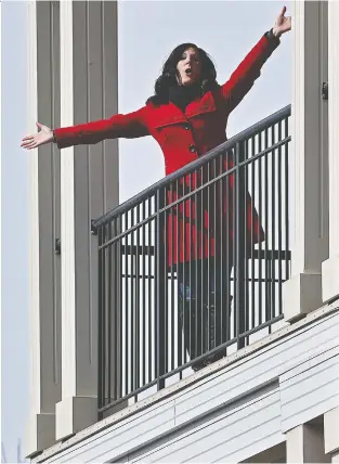  ?? ED KAISER ?? Opera singer Cara Lianne Mcleod was singing from her fourth floor balcony along 98 Ave. in Edmonton during the weekend. Stay tuned for more performanc­es, which can be seen from the footbridge in Cloverdale.
