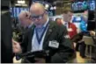  ?? RICHARD DREW — THE ASSOCIATED PRESS FILE ?? Trader Jeffrey Vazquez, center, works on the floor of the New York Stock Exchange.