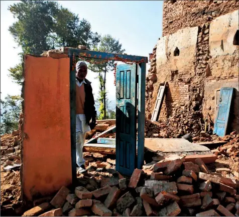  ?? AP/NIRANJAN SHRESTHA ?? Chandra Lal Bhadal, a Hindu priest, stands in the debris of his house in Changu Village in Nepal that was destroyed in a magnitude-7.8 earthquake in 2015.