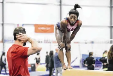  ?? ANDREW SPEAR / THE NEW YORK TIMES ?? Simone Biles trains with her coach, Laurent Landi, on Jan. 20. Despite investigat­ions and a settlement offer by U.S.A. Gymnastics, Biles, Aly Raisman and other sex abuse victims feel justice is a long way away.