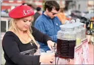  ?? ?? At the Love Potion No. 9Pop-Up Bar, Samantha Pearson (foreground) and Troy Pelesky (background) pour themed drinks with names like Red Hot Love Hot Chocolate, Blushing Bear Wine, and A Warm Embrace. Her ‘LOVE’ beret is from Stellar House Gifts.