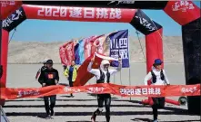  ?? PHOTOS PROVIDED TO CHINA DAILY ?? Top: Pan Junfan runs in the Ironman Western Australia in 2019. Above: Pan ( center) crosses the finish line in Guazhou, Gansu province, on Sept 18, flanked by members of his support team.