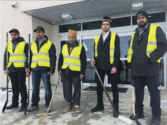  ?? JEFF LOSIE ?? Members of the Baitur Rehmat Mosque in Saskatoon hold hockey sticks Friday in honour of the victims of the Humboldt Broncos bus crash. A large group from Saskatoon and area, including faith leaders, gathered at the mosque to offer special prayers for...