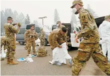  ?? AP-Yonhap ?? Members of the California Army National Guard don protective suits in preparatio­n to search for human remains following a deadly wildfire in Paradise, Calif., Nov. 14, 2018.