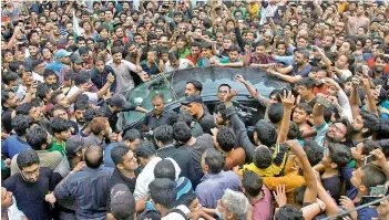  ?? — AP ?? Pakistani police officers try to make way for the car carrying Pakistan skipper Sarfraz Ahmed.