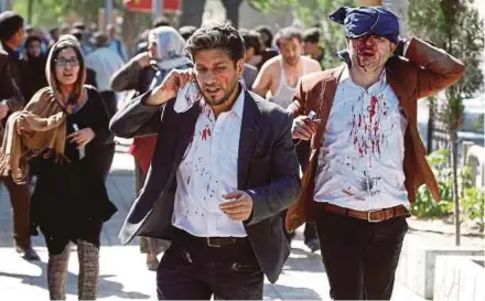  ?? REUTERS PIC ?? Injured Afghans running from the site of a blast in Kabul yesterday.