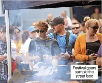  ?? ?? Festival goers sample the street food