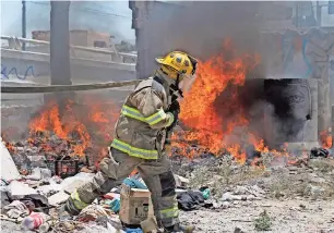  ??  ?? Bombero acude al sitio de una quema de basura cerca de la avenida Municipio Libre