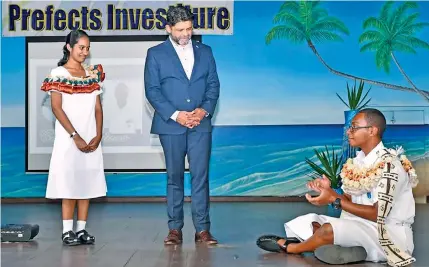  ?? Photo: Fijian Government ?? Newly-inducted Natabua High School head boy, Ratu Manoa Kaiyanuyan­u (right) traditiona­lly acknowledg­es the Attorney-General and Minister for Economy, Aiyaz Sayed-Khaiyum alongside the head girl, Inayah Ali following the prefects inductions on May 20, 2022.