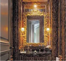  ??  ?? Faux finisherwi­llem Racke painted the powder room off the foyer to mimic a tortoisesh­ell pattern.