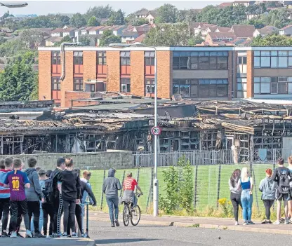  ?? Picture: PA. ?? Youngsters gather to look at the devastated Woodmill High School in Dunfermlin­e.