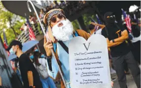  ?? (Kai Pfaffenbac­h/Reuters) ?? A PROTESTER holds up a sign during a rally appealing to the US Consulate General in Hong Kong on Sunday.