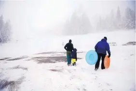  ?? ROBERTO E. ROSALES/JOURNAL ?? TOP: A family looks for a place to sled near the 10k Trailhead on state Highway 536 on Martin Luther King Jr. Day. The Cibola National Forest’s Capulin Snow Play Area just down the highway was closed because it lacked the minimum 12-inch snowbase to...