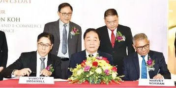  ??  ?? Wong (centre) witnesses the signing between Vivacity, represente­d by Yaw Hang (left) and Harvey Norman, represente­d by Aruldoss (right) while Alan (standing left) and Ng (standing right) looks on. — Photo by Tan Song Wei