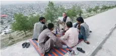  ?? — Reuters ?? Afghan men enjoy an evening on a hilltop overlookin­g Kabul.
