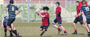  ?? PHOTO: TRACEY ROXBURGH ?? Through the gap . . . Ashburton College’s Thomas Patterson spots a gap in an under15 rugby match against Wakatipu High School at Queenstown yesterday.