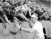  ??  ?? UF coach Dan Mullen celebrates with fans following the Gators’ 27-19 victory over the LSU Tigers on Saturday.