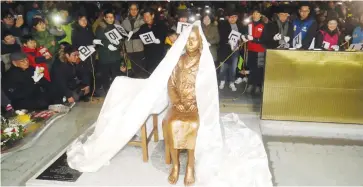  ?? (Yonhap/Reuters) ?? A STATUE of a girl that represents the sexual victims by the Japanese military is unveiled during a rally in front of the Japanese Consulate in Busan, South Korea, in December.