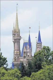  ?? JOHN RAOUX - THE ASSOCIATED PRESS ?? This photo shows the top of the newly painted Cinderella Castle in the Magic Kingdom from World Drive at Walt Disney World on Thursday, July 2, in Lake Buena Vista, Fla. Magic Kingdom and Animal Kingdom will reopen on July
11. Disney World’s other two parks, Epcot and Disney’s Hollywood Studios, will welcome back guests four days later.