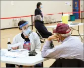  ??  ?? Community Health RN Mary- Ellen M Roberts discusses the COVID-19 vaccine with Siksika Nation Elder Norman Running Rabbit at at the clinic Feb. 10.