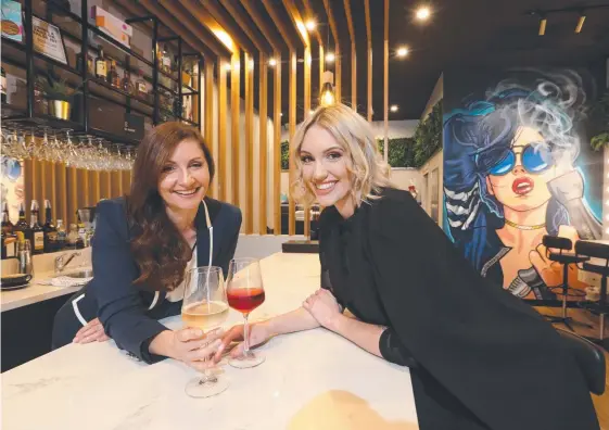  ?? Picture: GLENN HAMPSON ?? Blow Bar Lane owner Susan Gryparis toasts their success with salon manager and daughter Nikki Gryparis at their Surfers Paradise venue.