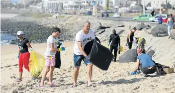  ?? Pictures: ALAN EASON ?? SISYPHEAN TASK: Community members rally to clean up Eastern Beach, collecting hundreds of items of trash.