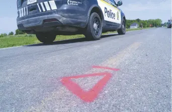  ??  ?? Une voiture de police roule le long du Rang Sainte-Anne à Notre-Dame-de-Stanbridge, au Québec. - La Presse canadienne: Paul Chiasson