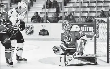  ?? Red Deer Advocate photo by Byron Hacket ?? Lethbridge Hurricanes goalie Logan Flodell makes as save as Red Deer Rebels forward Reese Johnson and Hurricanes defenceman Calen Addison look on during the first period of Game 3 in the Eastern Conference quarter-final in Red Deer on Tuesday.