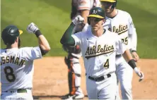  ?? Santiago Mejia / The Chronicle ?? New A’s infielder Jake Lamb (4) celebrates his tworun home run with teammate Robbie Grossma on Saturday in Oakland.
