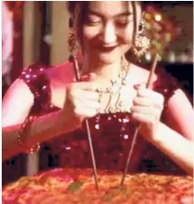  ??  ?? Tasteless: A screenshot from Dolce &amp; Gabbana’s ‘ The Great Show’ promotiona­l clip showing a woman struggling to use chopsticks to eat her pizza.