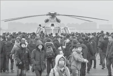  ?? CHEN XIAO / FOR CHINA DAILY ?? People take a close look at the AC352 utility helicopter after it finished its maiden flight in Harbin, Heilongjia­ng province, on Tuesday.
