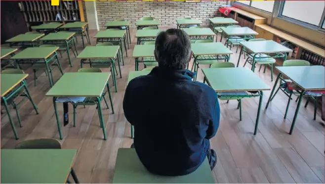  ??  ?? Un profesor contempla un aula vacía en un colegio de Aranda de Duero (Burgos).