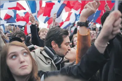  ?? AP PHOTO ?? Supporters of French independen­t centrist presidenti­al candidate Emmanuel Macron kiss as they celebrate outside the Louvre museum in Paris Sunday. Centrist Macron is France’s next president, putting a 39-year-old political novice at the helm of one of...