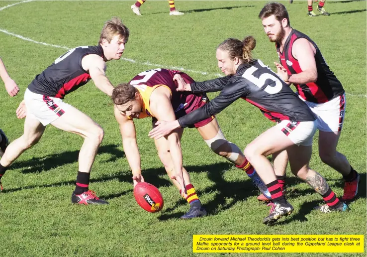  ??  ?? Drouin forward Michael Theodoridi­s gets into best position but has to fight three Maffra opponents for a ground level ball during the Gippsland League clash at Drouin on Saturday. Photograph: Paul Cohen