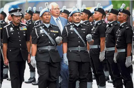  ??  ?? Honoured: Najib and Mustafar inspecting a guard of honour during the e-visa facility and system launch in Putrajaya. — Bernama