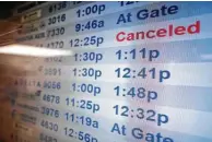  ?? ?? A board at JFK airport shows a flight cancellati­on on Wednesday. The TSA expects the Monday after New Year’s will be one of the busiest days of the season.