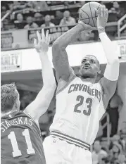  ?? Ron Schwane / Associated Press ?? The Cavaliers’ LeBron James (23) shoots over Philadelph­ia’s Nik Stauskas in Friday’s game.