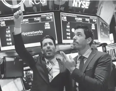  ?? RICHARD DREW / THE ASSOCIATED PRESS FILES ?? Jonathan Scott, left, and Drew Scott of the Property Brothers mimic traders when they visited the New York Stock Exchange in 2014. The Property Brothers is made by Cineflix, a company which is the target of a class-action lawsuit.