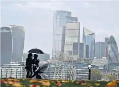  ??  ?? A buggy, two coffees and a shared umbrella against grey skies over the City of London