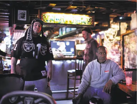  ?? Carlos Avila Gonzalez / The Chronicle ?? Justin Reina of Oakland and Ivan Davis (right) listen to the news of the Raiders’ move to Las Vegas at Ricky’s Sports Theatre and Grill in San Leandro. The NFL announced that team owners had approved the Raiders’ departure 31-1.