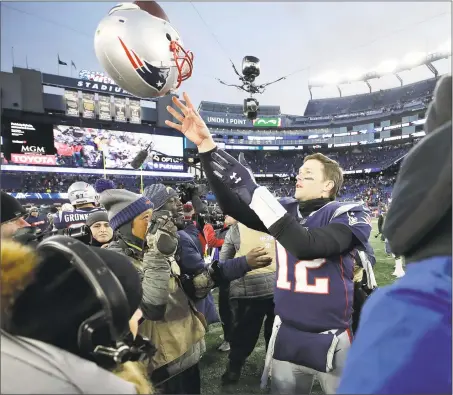  ?? Elise Amendola / Associated Press ?? Patriots quarterbac­k Tom Brady tosses his helmet to an equipment personnel member after Sunday’s AFC divisional playoff game against the Chargers in Foxborough, Mass. The Patriots won 41-28.