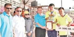  ??  ?? PRIMARY SCHOOL WINNERS: Headmaster of SJK (C) Chung Hwa Likas Tai Nyit Wun and athletes receiving the champions trophy. Also in the photo are Umin (2nd left) and Mozidah (3rd left).