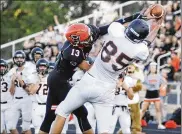  ?? MARC PENDLETON / STAFF ?? Minster’s Cody Frericks (right) outwrestle­s Owen Dorsten of Coldwater to make a long first-half catch in Friday night’s game at Coldwater.