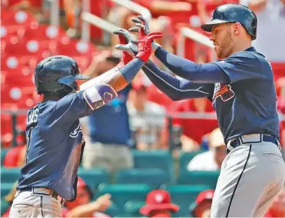  ?? THE ASSOCIATED PRESS ?? The Atlanta Braves’ Freddie Freeman, right, is congratula­ted by teammate Ozzie Albies after hitting a two-run home run during the sixth inning of Sunday’s game against the St. Louis Cardinals. It was Freeman’s 16th homer of the season.