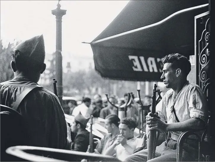  ?? JUAN GUZMAN / EFE ?? Unos milicianos armados descansan en una terraza de un céntrico café de Barcelona en la m,añana del 19 de julio de 1936